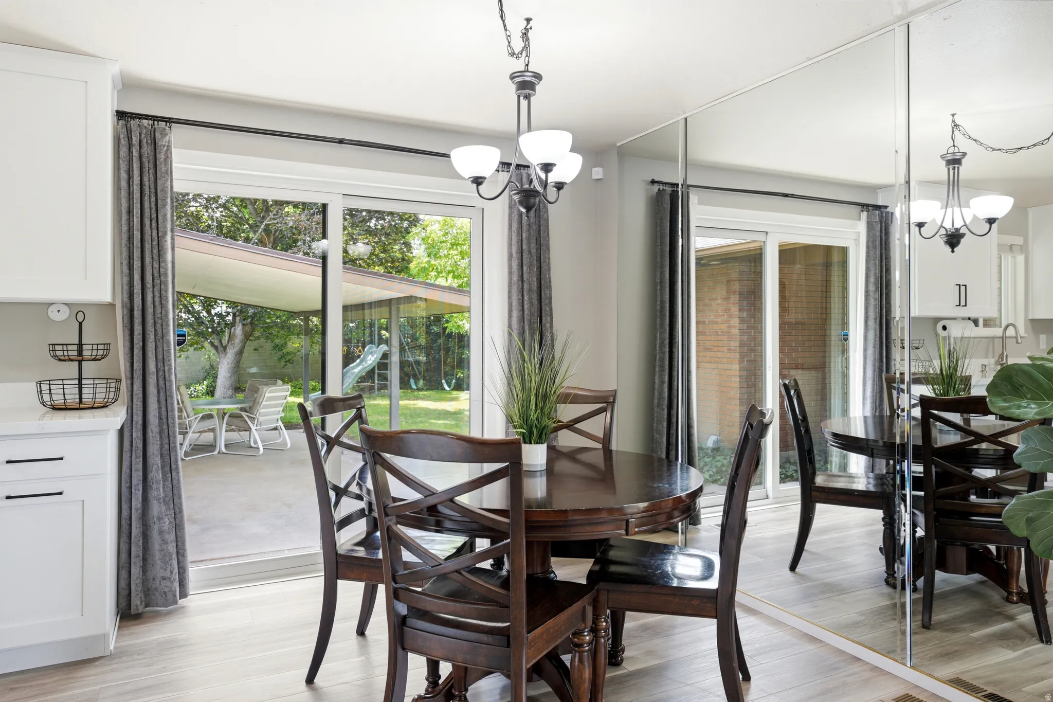 Dining area with wood-finish flooring and a contemporary light fixture