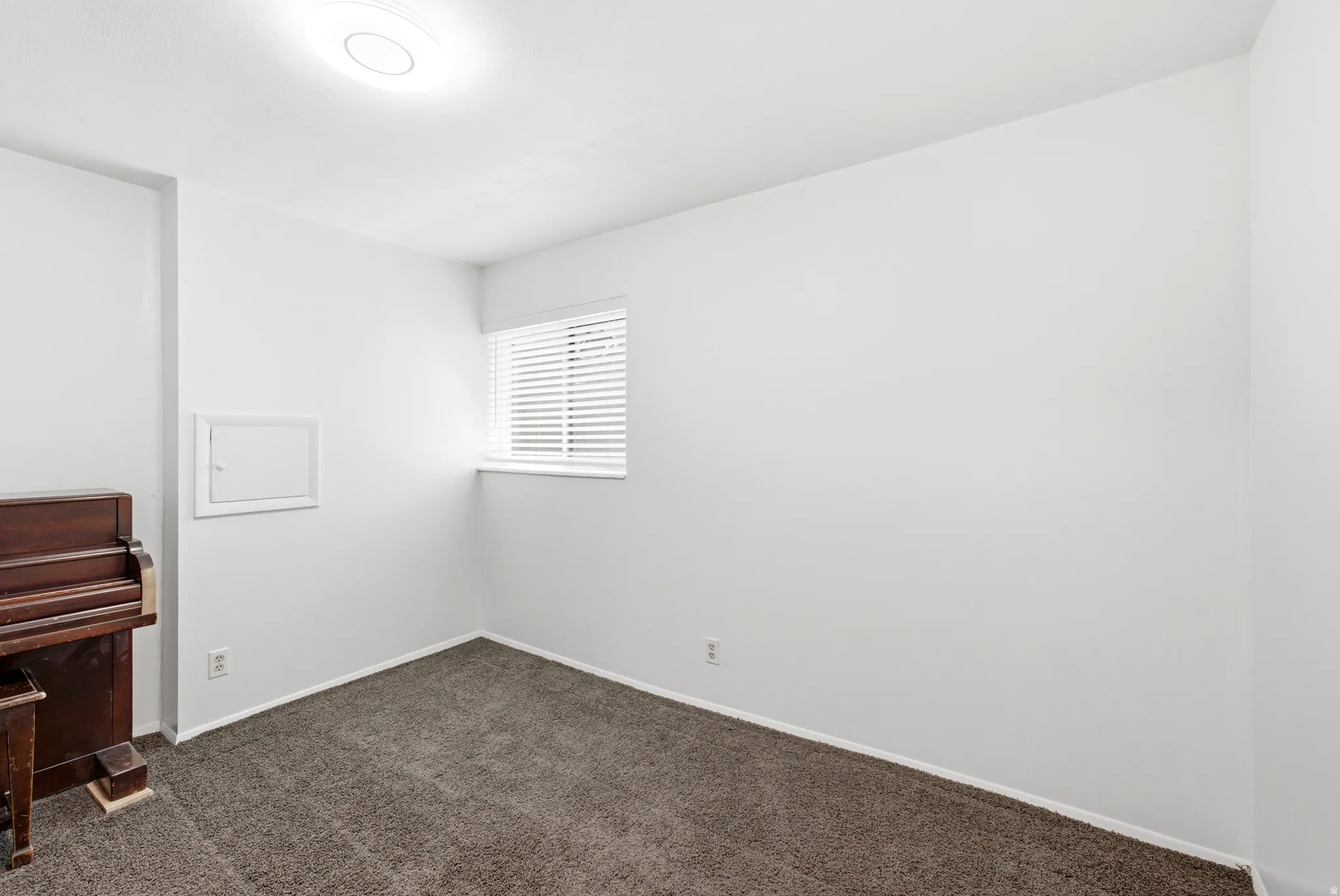 Room featuring neutral wall finishes and a window with horizontal blinds