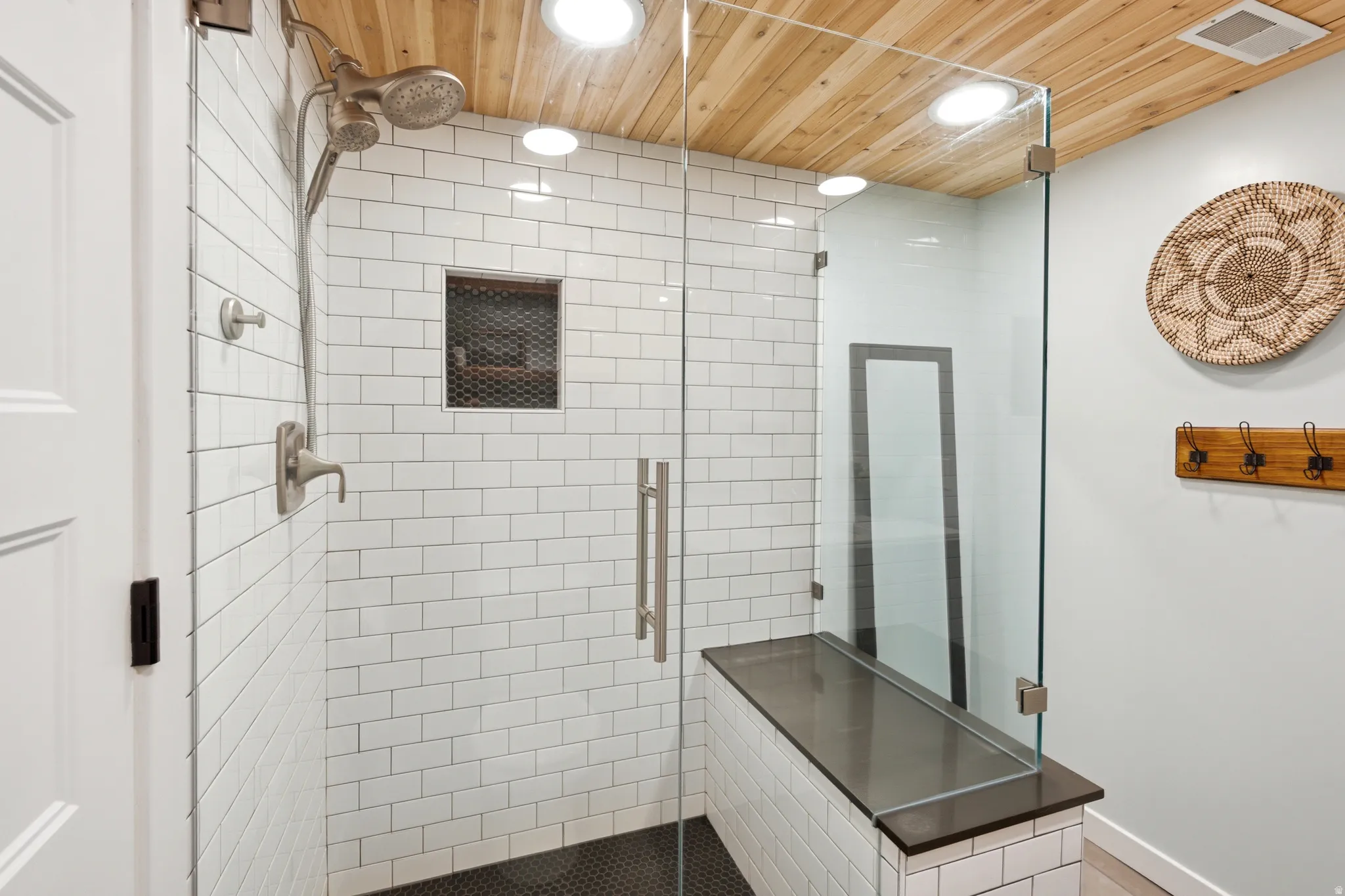 Walk-in shower with clear glass enclosure and built-in bench