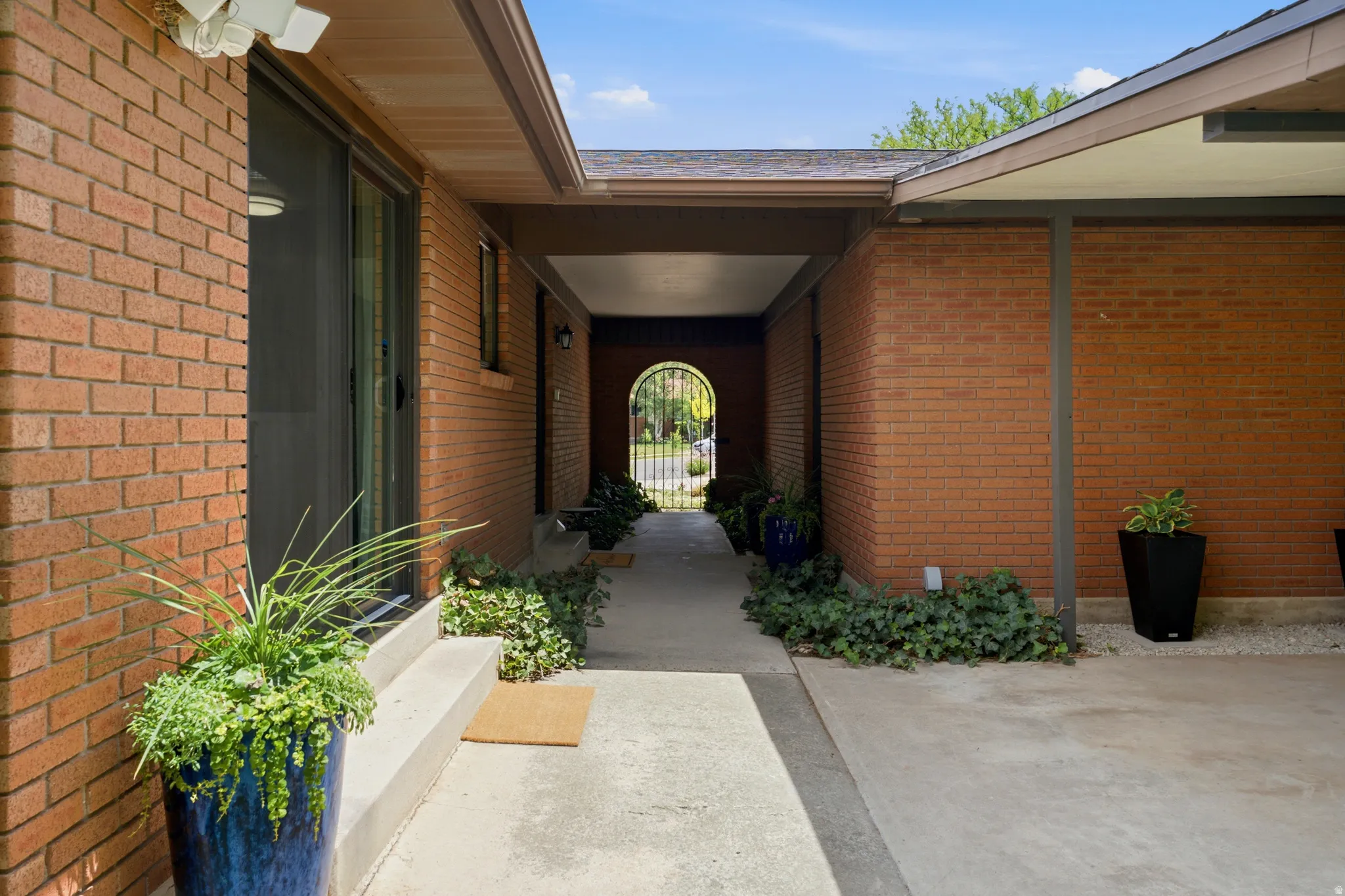 Covered entryway featuring brick construction and concrete flooring