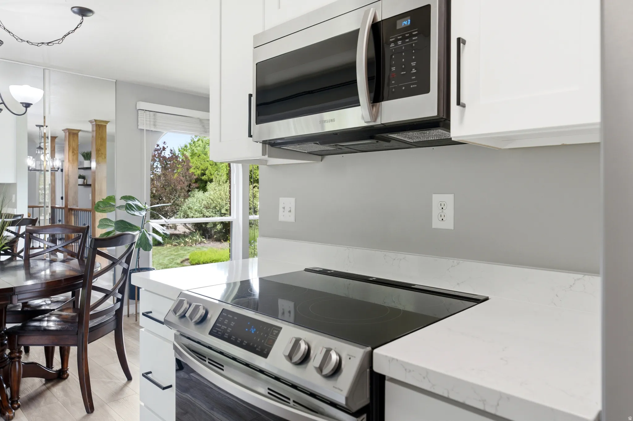 Modern kitchen featuring white cabinetry, a stainless steel microwave, and an electric range with a smooth cooktop