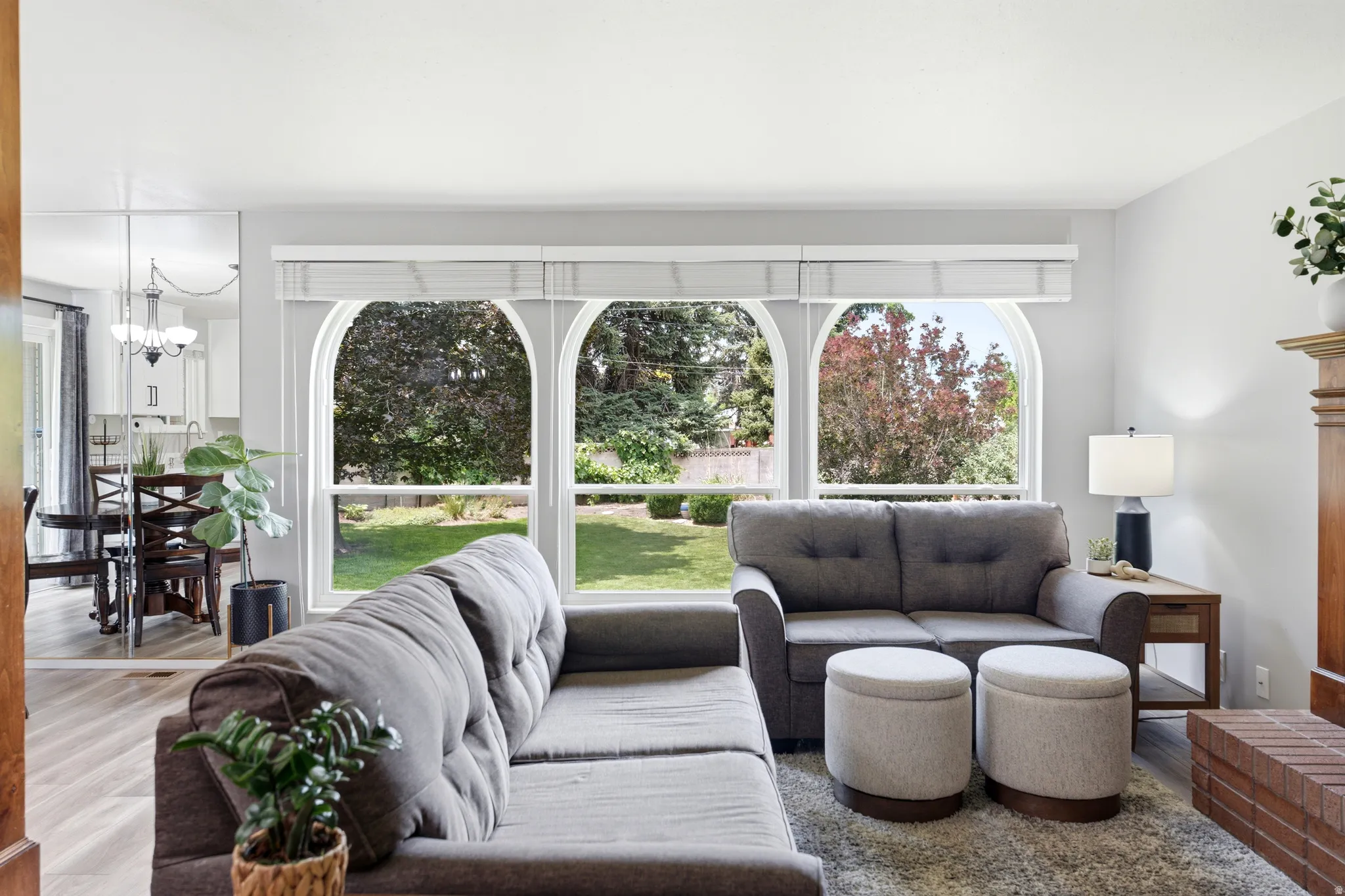 Living area with three arched windows overlooking exterior landscaping