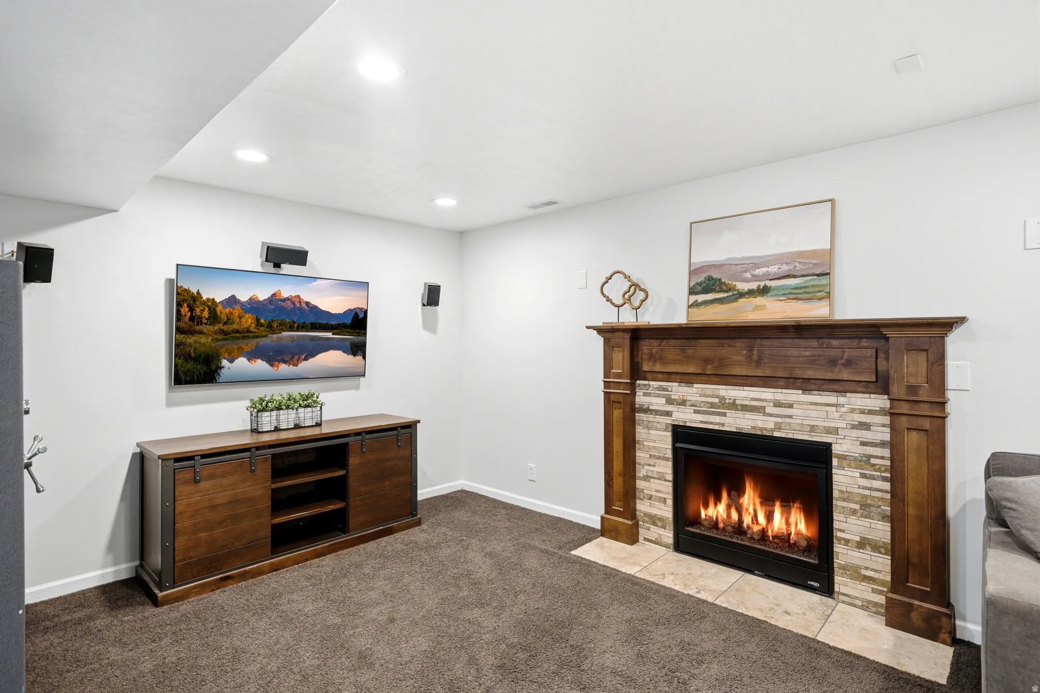 Fireplace with a wood mantel and stacked stone surround