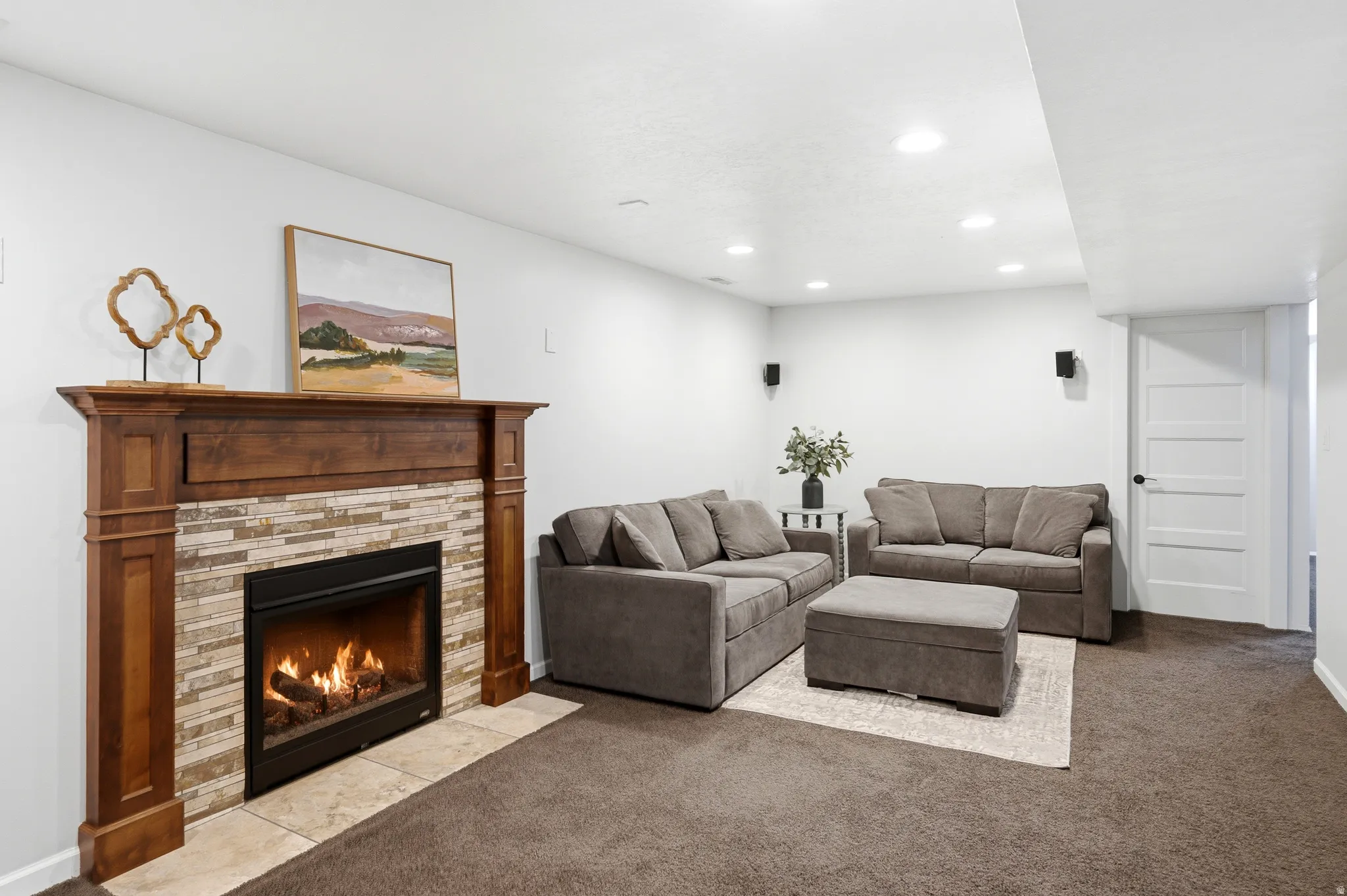 Fireplace featuring a wood mantel, stone surround, and tile hearth