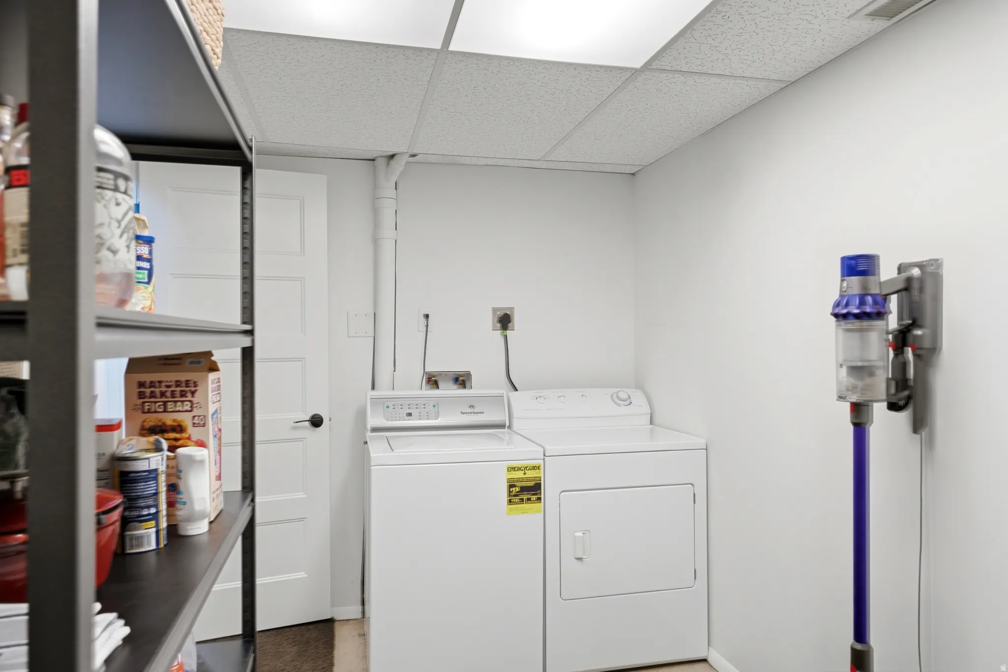 Dedicated laundry area featuring a washer and dryer, white walls, and a drop ceiling