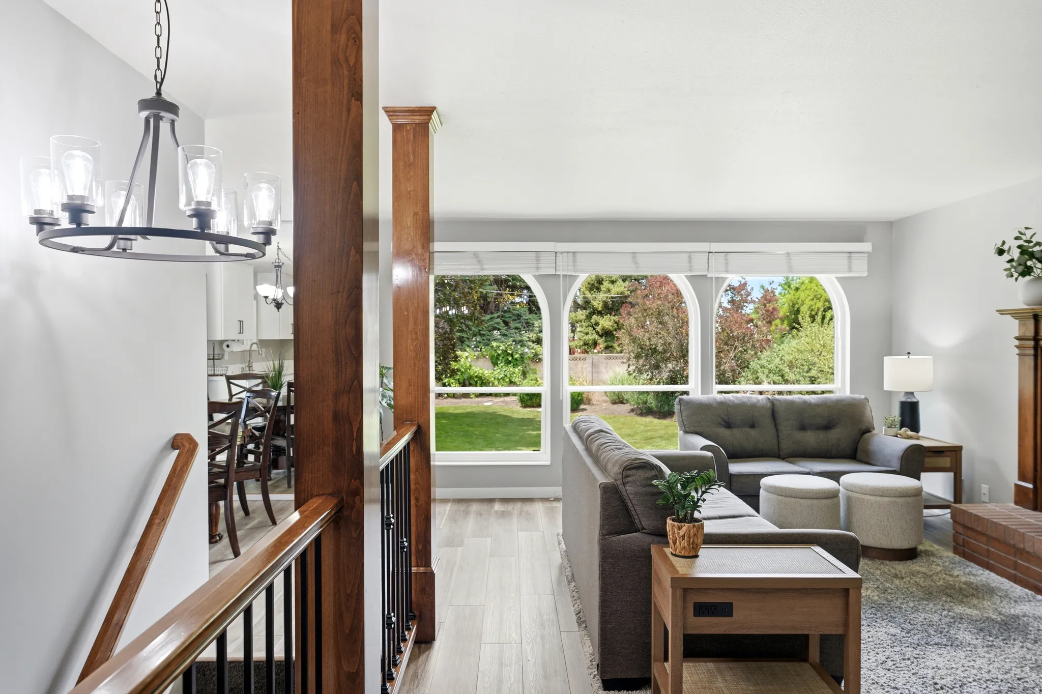 Living area featuring arched windows, wood-finish flooring, and a brick hearth