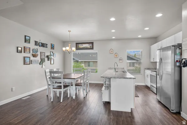 Open-concept kitchen and dining area featuring dark wood-finish flooring