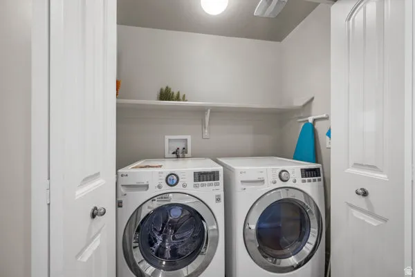 Dedicated laundry area featuring a built-in shelf, overhead lighting, and white paneled doors