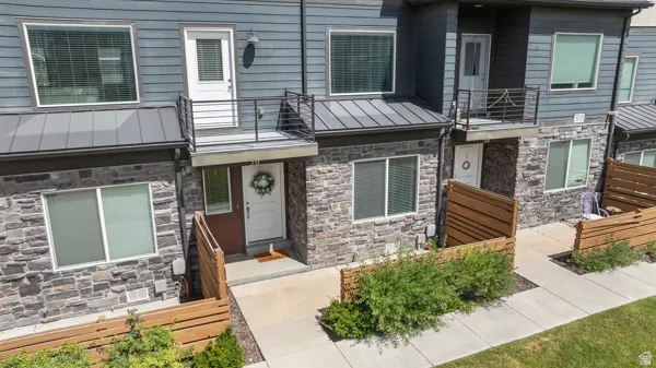Contemporary townhome exterior featuring two levels of stone veneer and horizontal siding