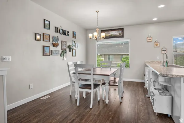 Dining area featuring wood-finish flooring, a contemporary chandelier, and recessed lighting