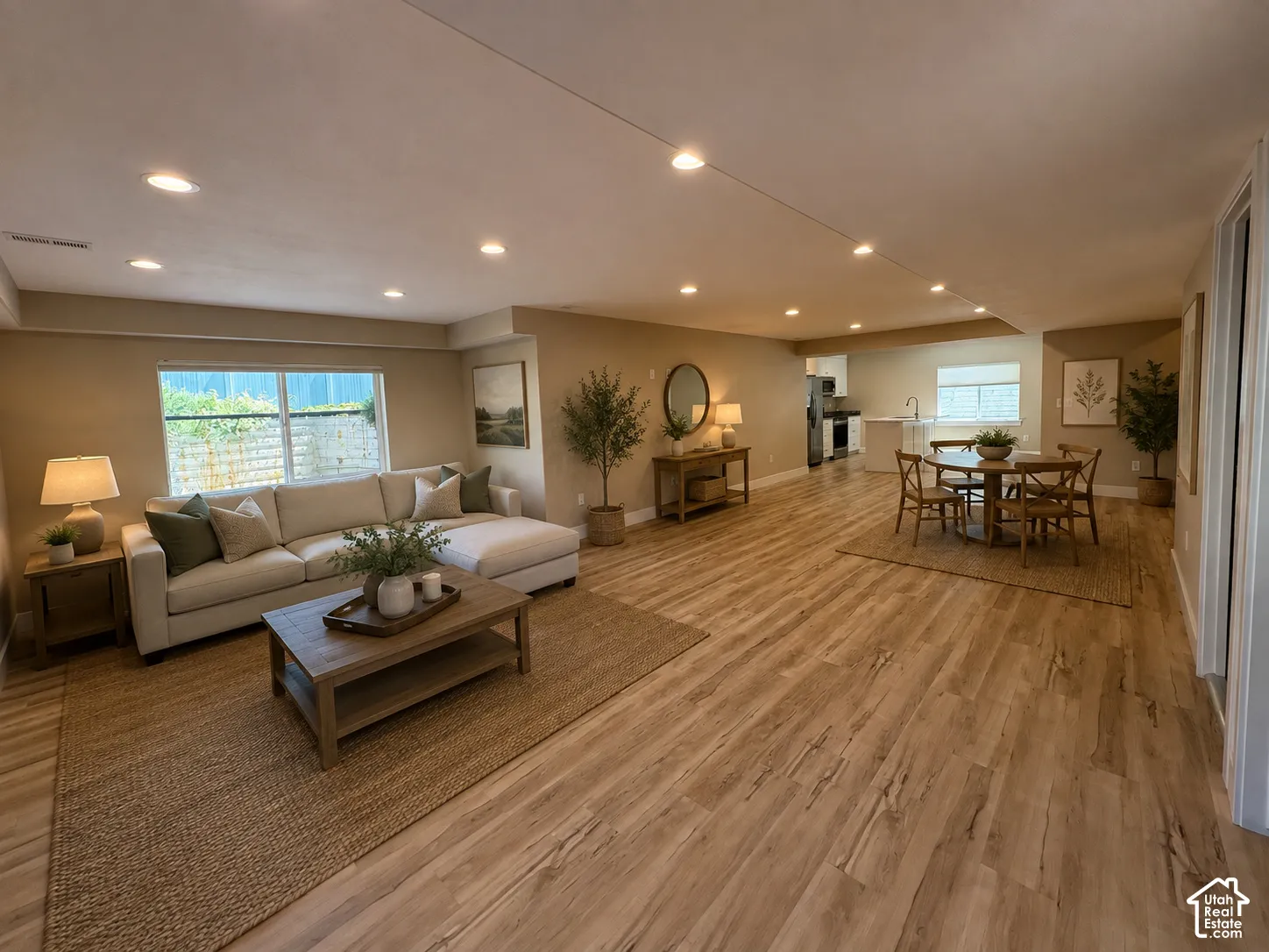 Spacious ADU with open-concept living area featuring wood-finish flooring, recessed lighting, and a large window