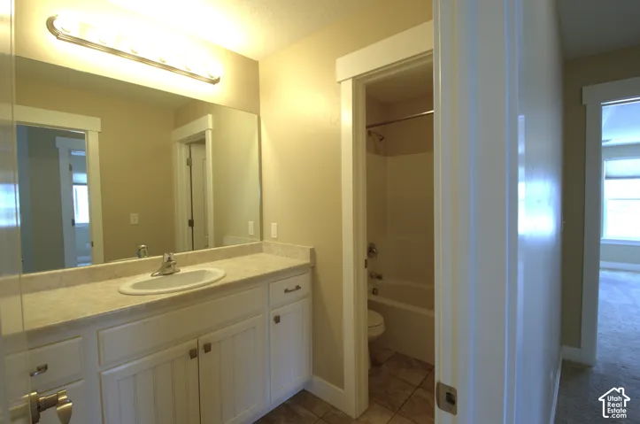 Bathroom vanity featuring a single basin sink, laminate countertop, and white cabinetry with beadboard paneling