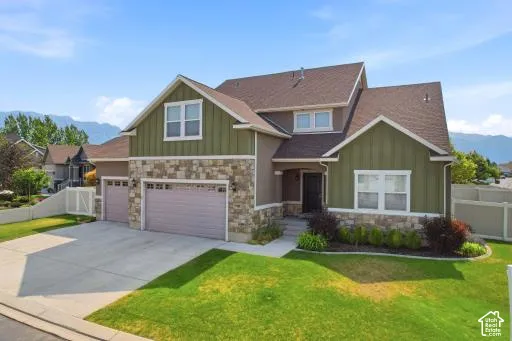 Two-story residence featuring a combination of stone veneer and vertical siding accents