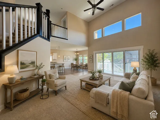 Two-story living area with high ceilings, center opening sliding glass doors that open onto a deck over looking a large backyard. AI staged