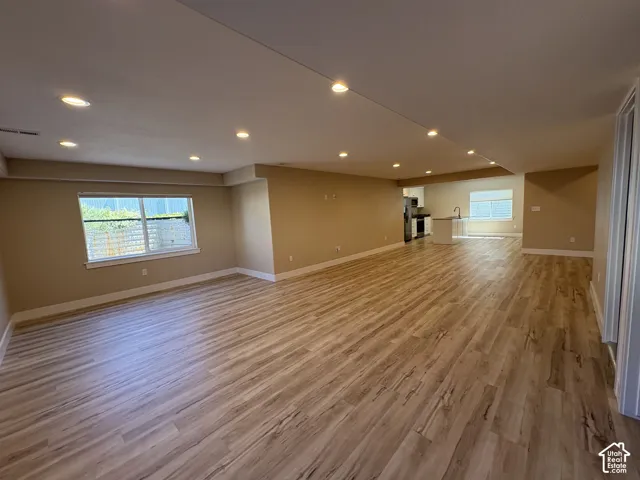 Open-concept living space featuring wood-finish flooring, recessed lighting, and neutral wall tones