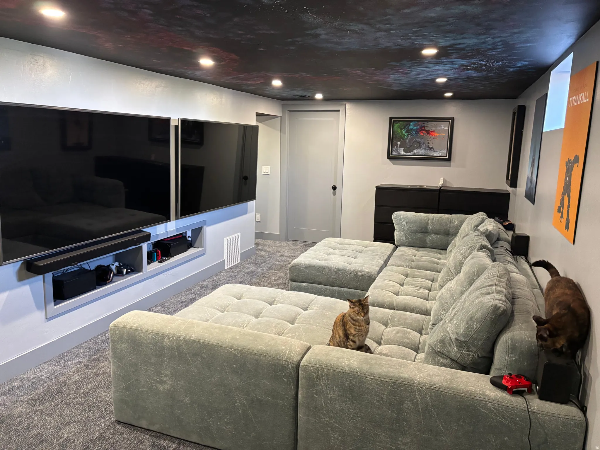 Media room featuring recessed lighting, a custom painted ceiling, built-in wall niches for media components, and neutral wall tones