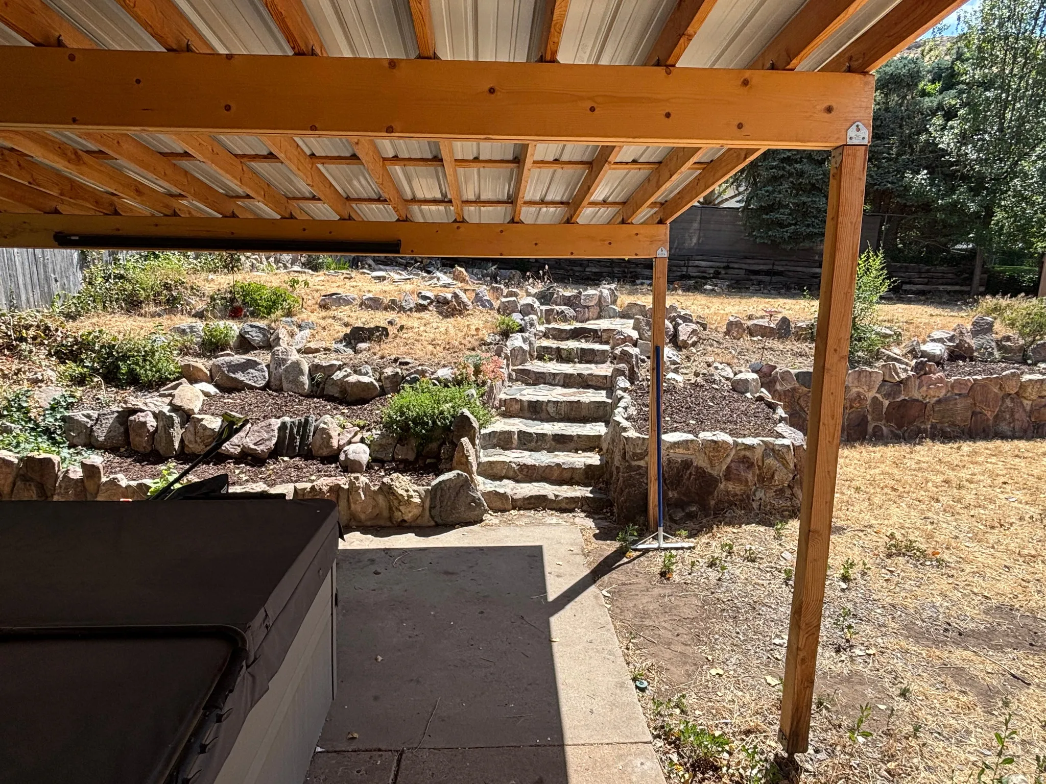 Covered patio featuring a metal roof and exposed wood beams