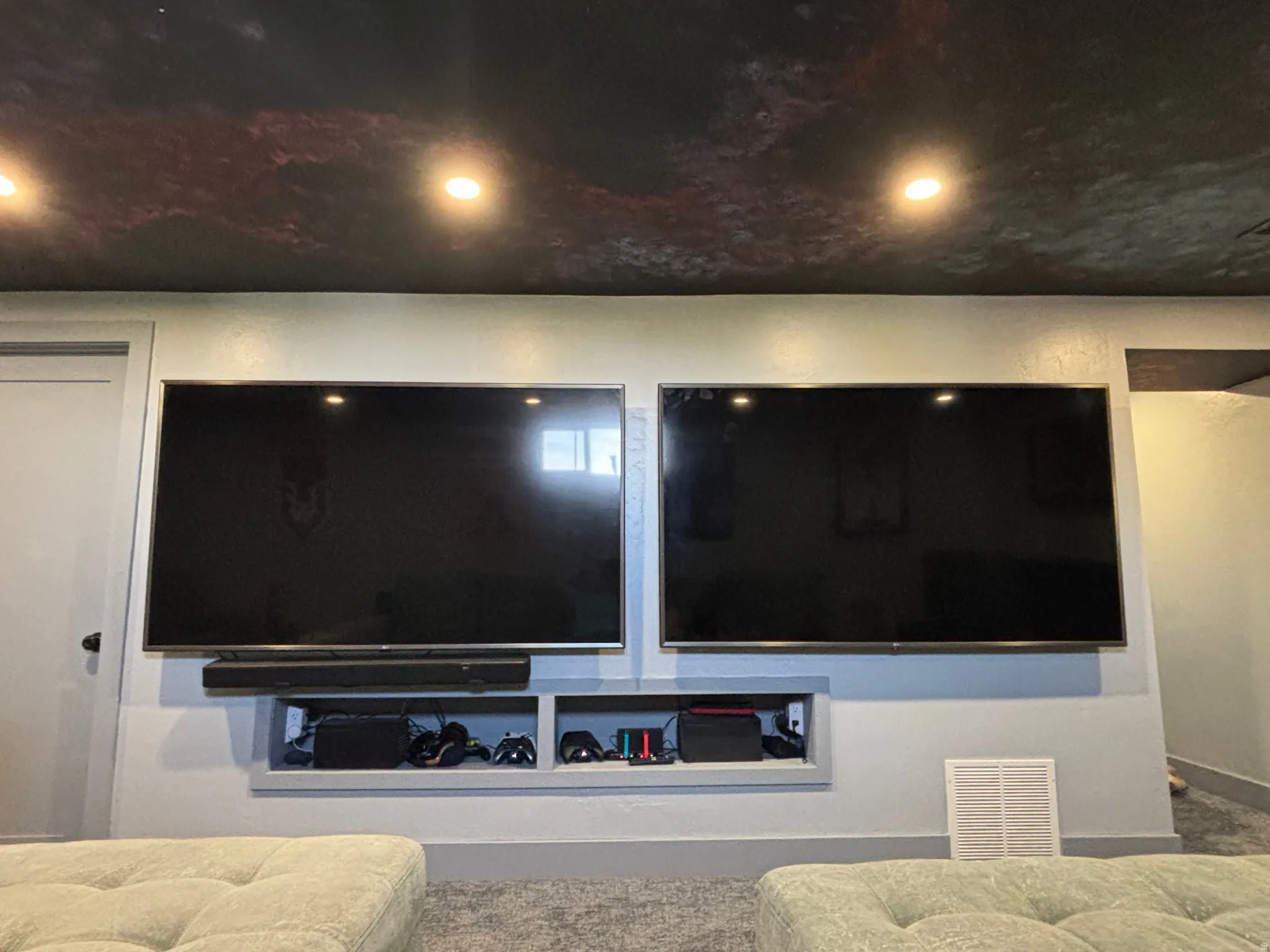 Recessed niche with built-in shelving, dual wall-mounted displays, and integrated sound bar