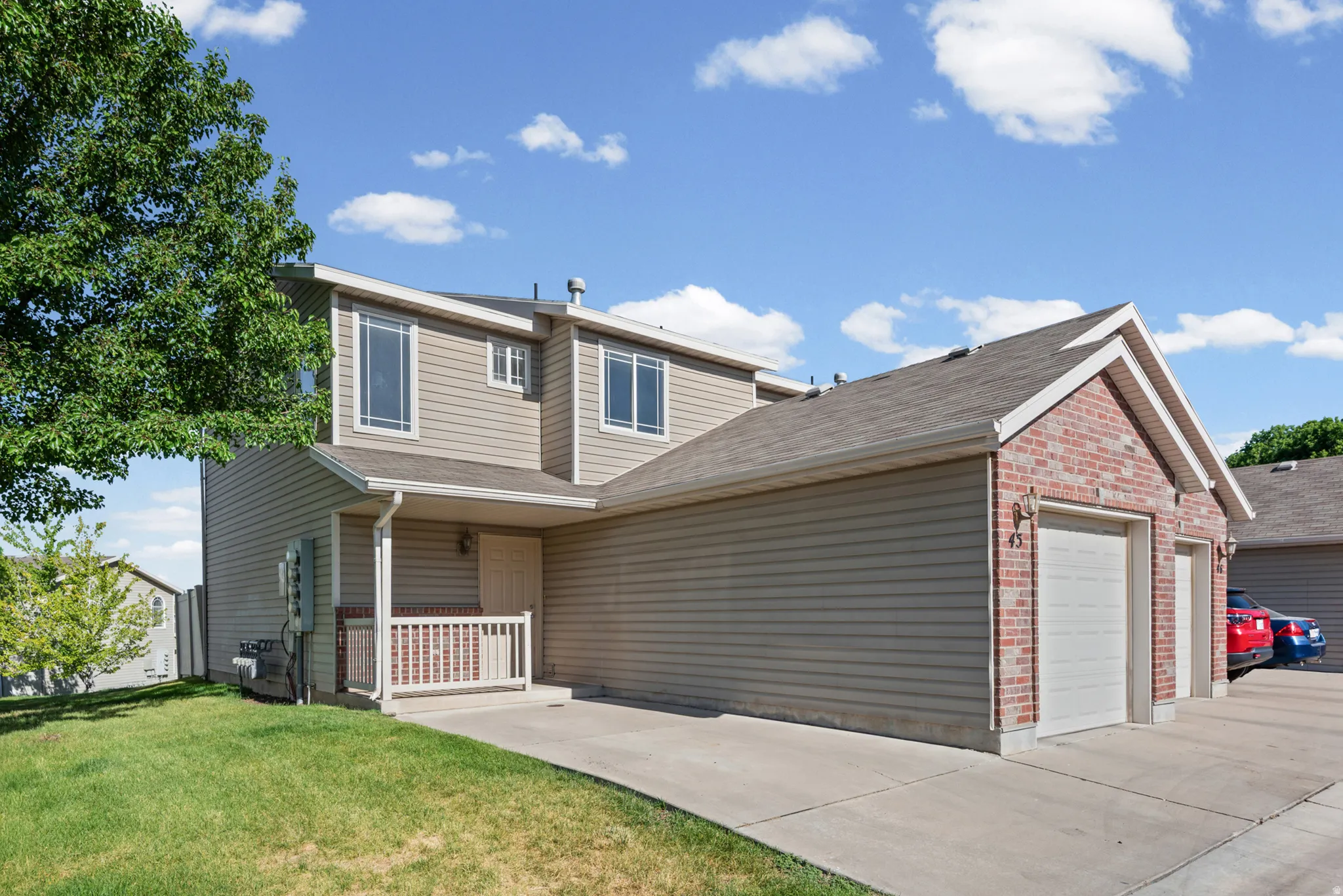 Two-story exterior with light-toned siding and brick accents