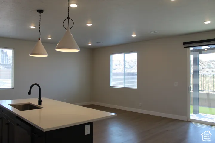 Kitchen island featuring a stainless steel sink, matte black faucet, and white countertop