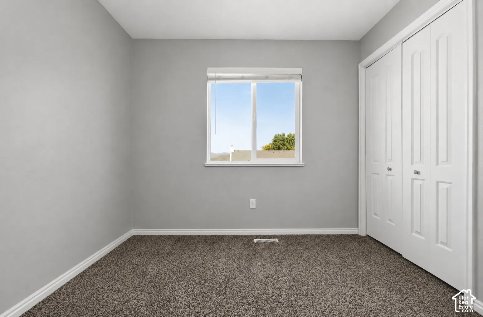Neutral gray wall paint, white trim, and dark carpeting