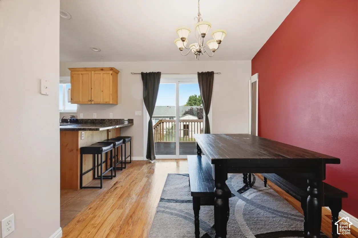 Dining area featuring wood-finish flooring and a red accent wall