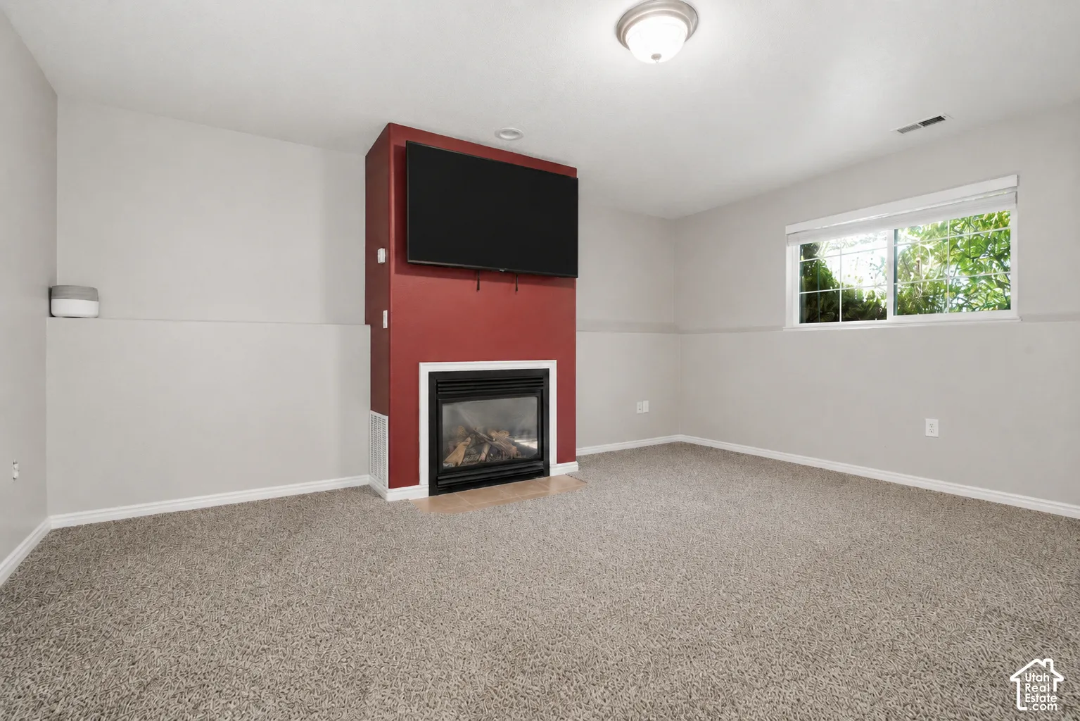 Living area featuring a floor-to-ceiling accent wall with a built-in fireplace and integrated media space