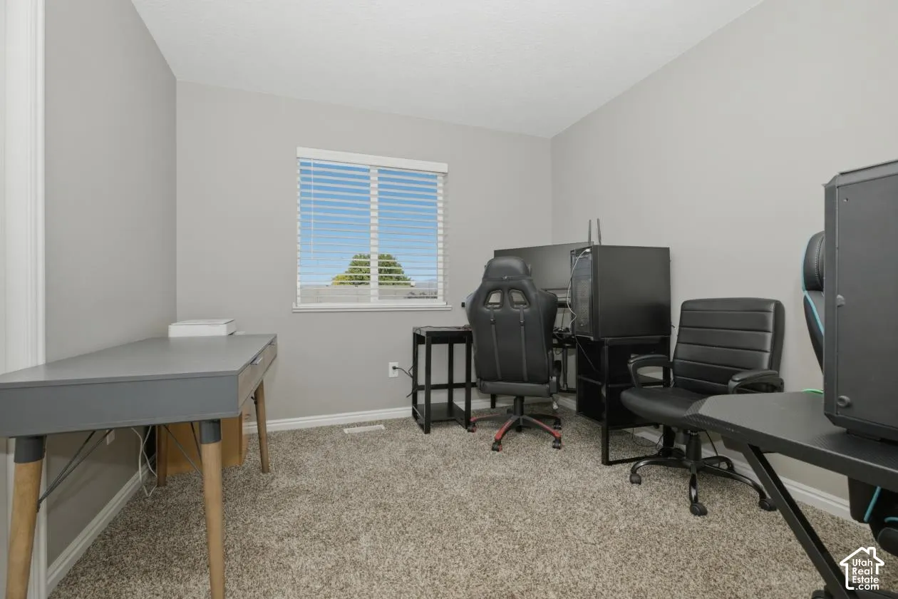 Carpeted room with a window featuring horizontal blinds