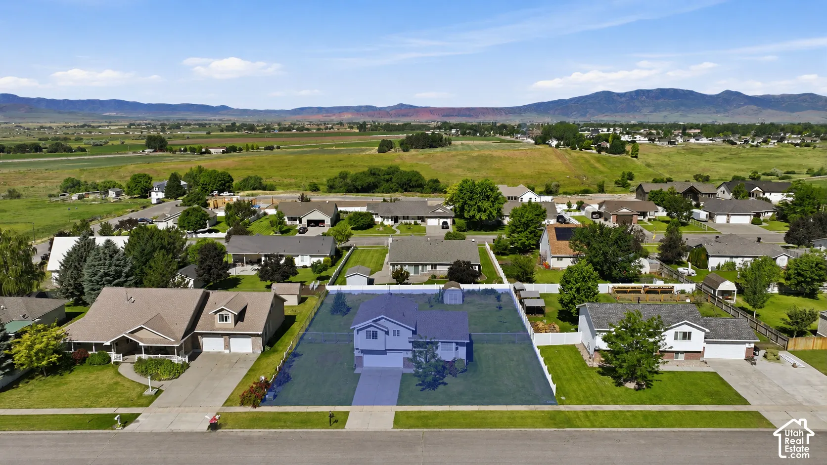 Aerial perspective highlighting a single-family residence with an attached garage, front yard, and backyard