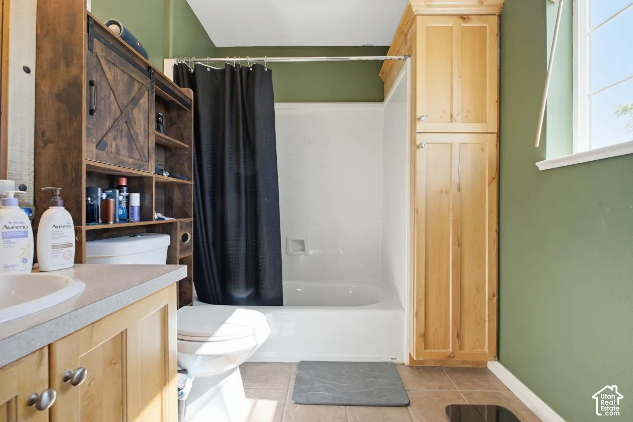 Bathroom featuring a white tub/shower combination, a light-colored vanity with a built-in sink, and a window with white trim