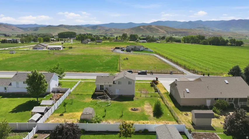 Rear exterior featuring a deck, a fenced yard, and a greenhouse