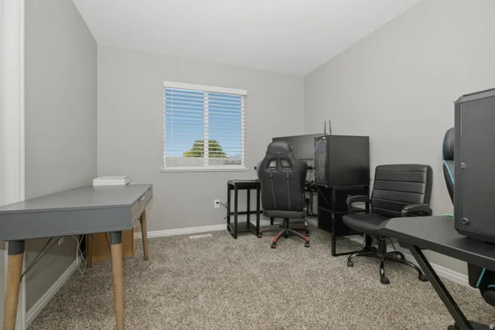Carpeted room with a window featuring horizontal blinds