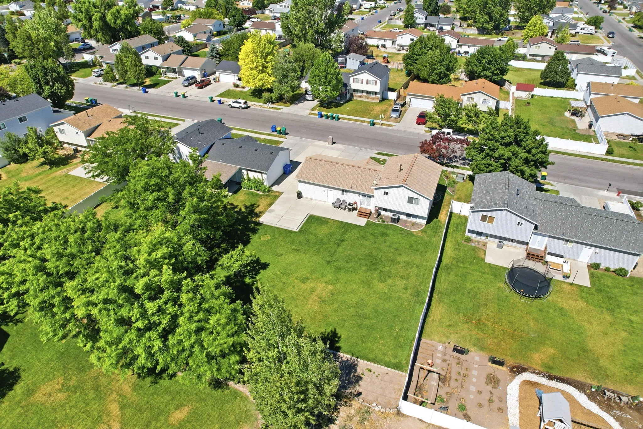 Expansive rear yard featuring a large manicured lawn and mature trees