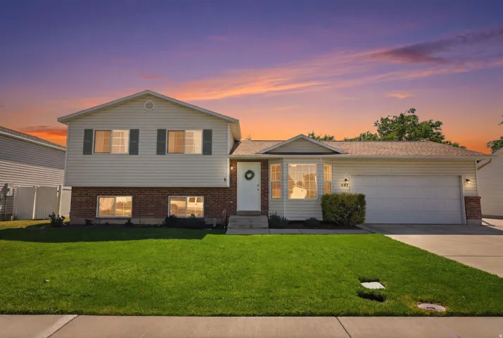 Split-level exterior featuring light-colored siding and brick accents