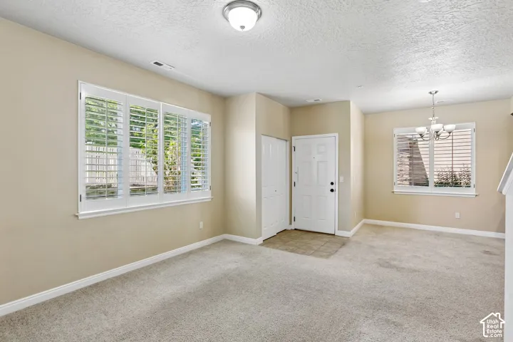 Entryway featuring a white paneled door, a tiled landing, new carpet, and an adjacent closet
