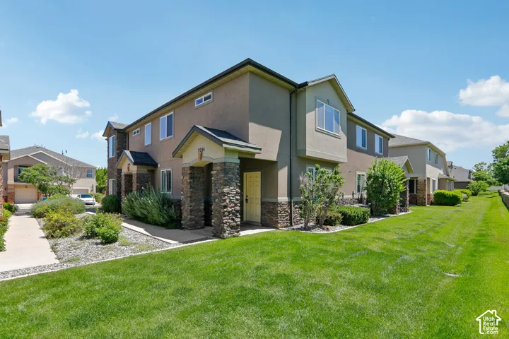 Multi-story townhome with stucco exterior and stone veneer accents