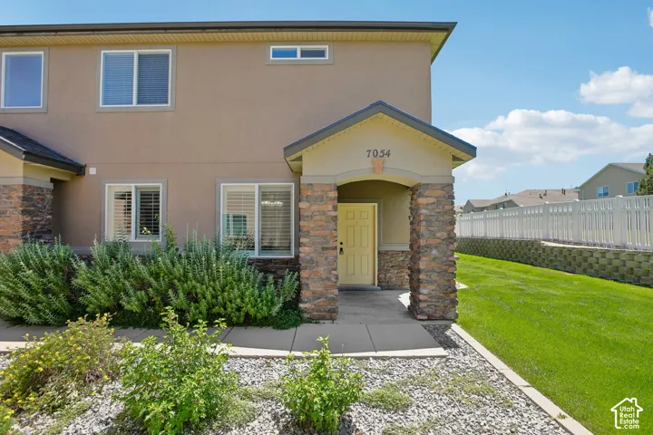Stucco exterior with stone accents and a covered entry