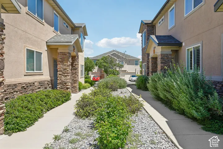 Pedestrian pathways flanked by manicured landscaping and stone accents
