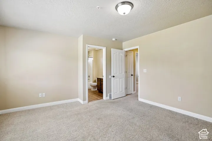 Carpeted room with neutral wall tones and white baseboards