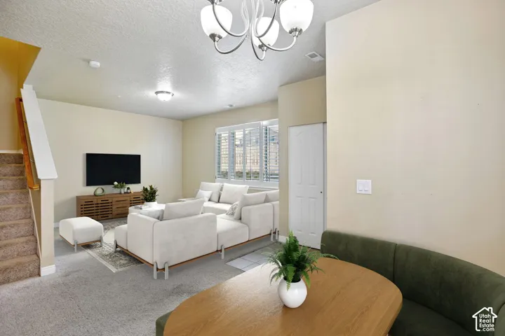 Open-concept living space featuring carpet flooring and ample natural light. Virtually staged.