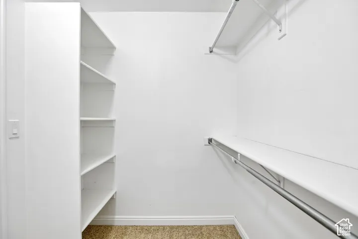Primary bedroom Walk-in closet featuring built-in shelving, two hanging rods, and an upper storage shelf