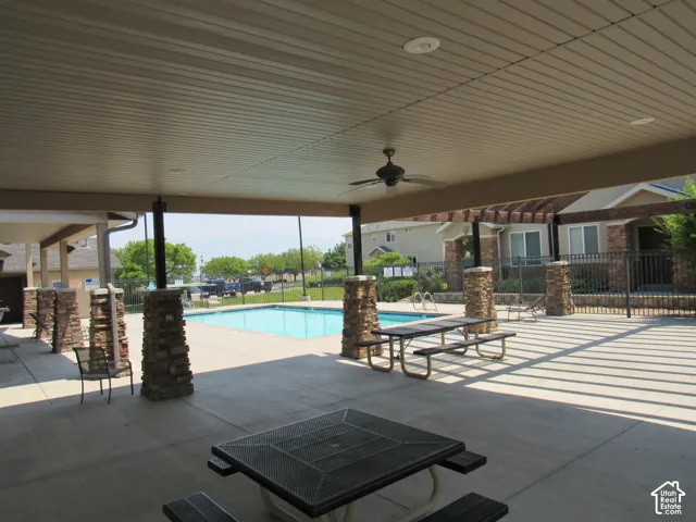 Covered patio with a ceiling fan, recessed lighting, and stone-clad support columns