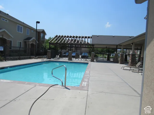 Outdoor swimming pool featuring a concrete deck and metal pool rails