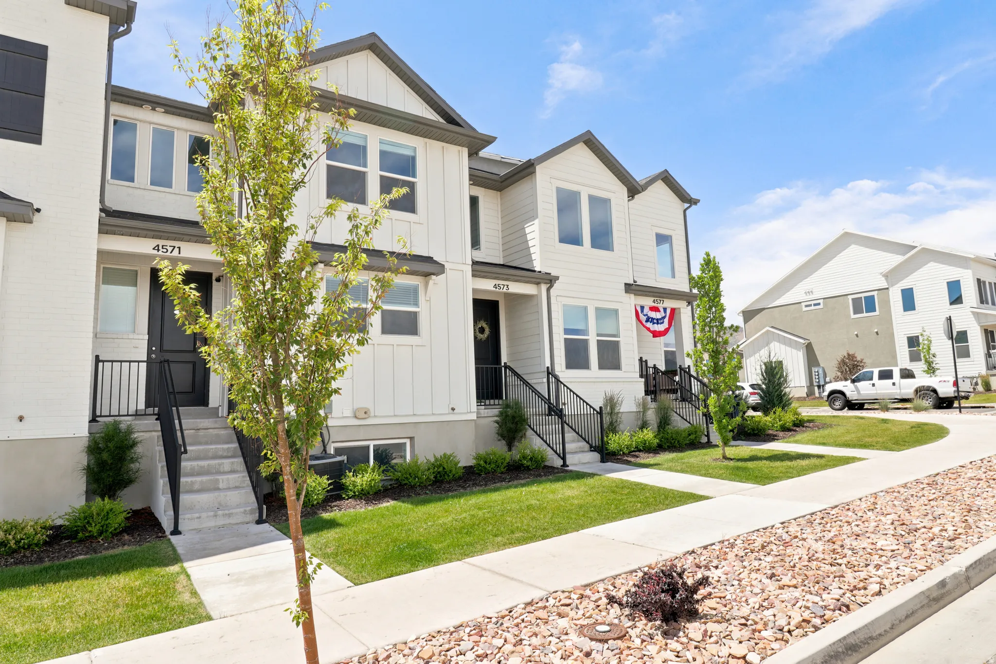 Contemporary townhome with a white facade and dark trim accents