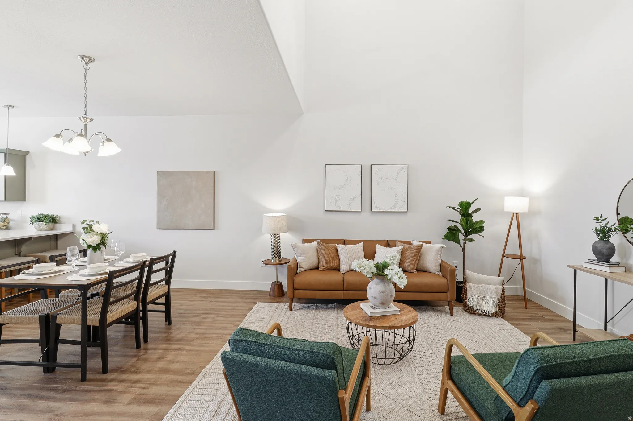Living area featuring high vaulted ceilings, wood-finish flooring, a contemporary chandelier, and recessed lighting