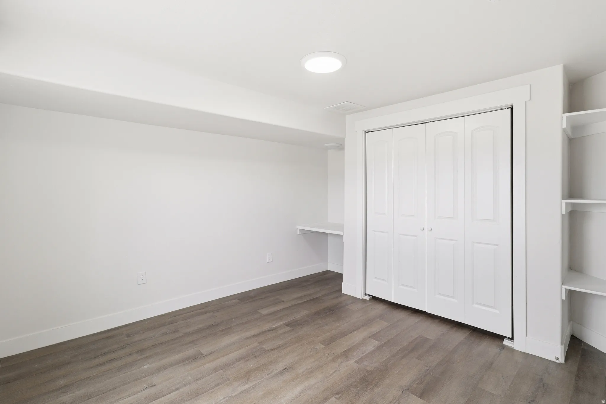Interior room featuring wood-finish flooring and white walls