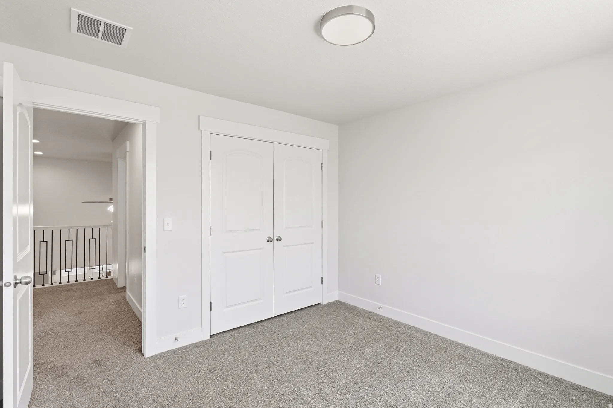 Bedroom featuring plush grey carpeting, white walls, and a contemporary flush-mount ceiling light