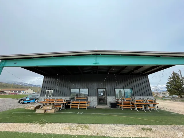 Commercial building featuring a prominent turquoise beam structure and dark paneling