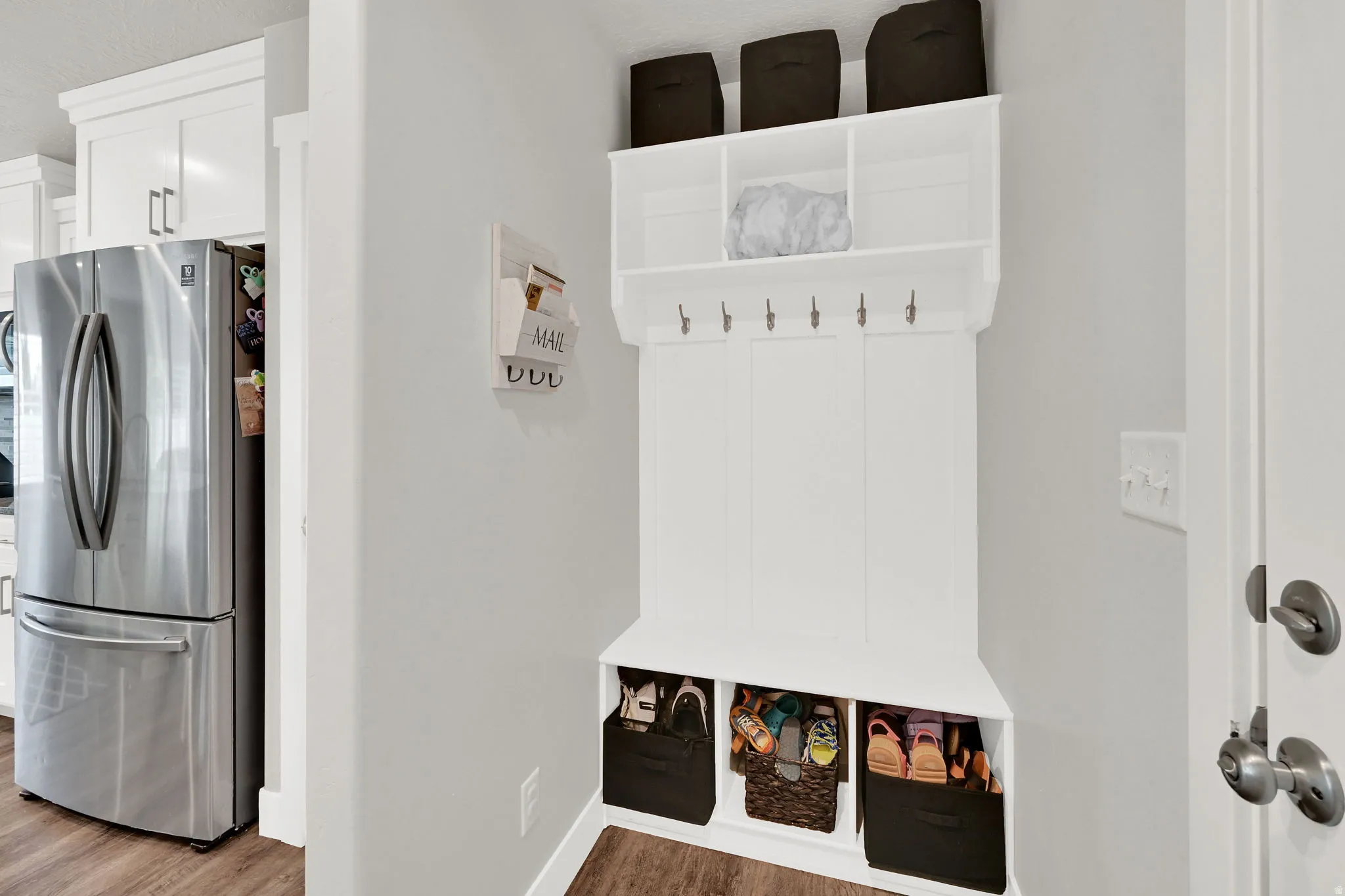 Built-in hall tree with upper shelving, coat hooks, and lower cubbies, complemented by LVP flooring