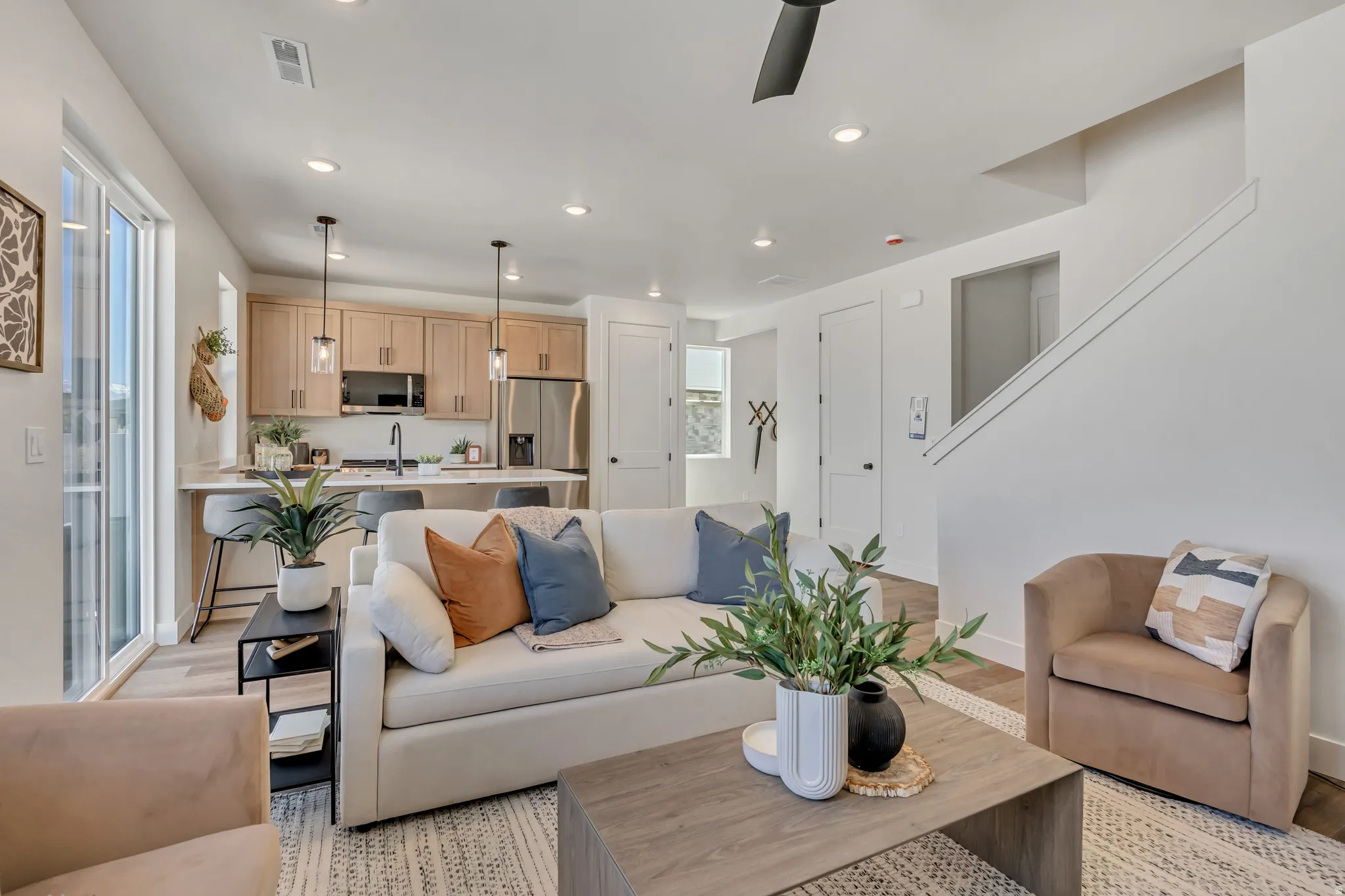Open-concept living space featuring wood-finish flooring, recessed lighting, and a modern ceiling fan